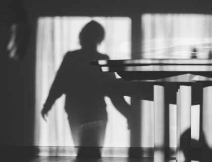 a shadow of a person standing in front of a table