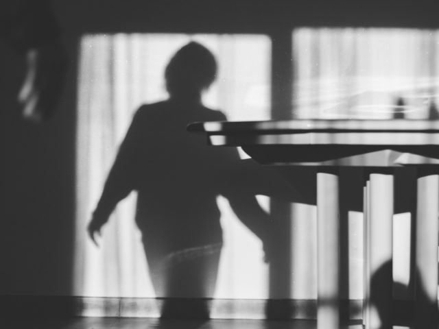 a shadow of a person standing in front of a table