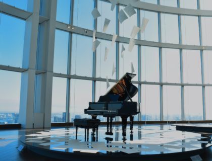 a grand piano in front of a large window